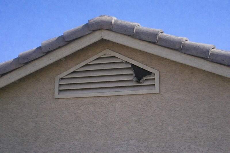 A louvered gable vent screened from behind on the stucco gable of an older Phoenix house